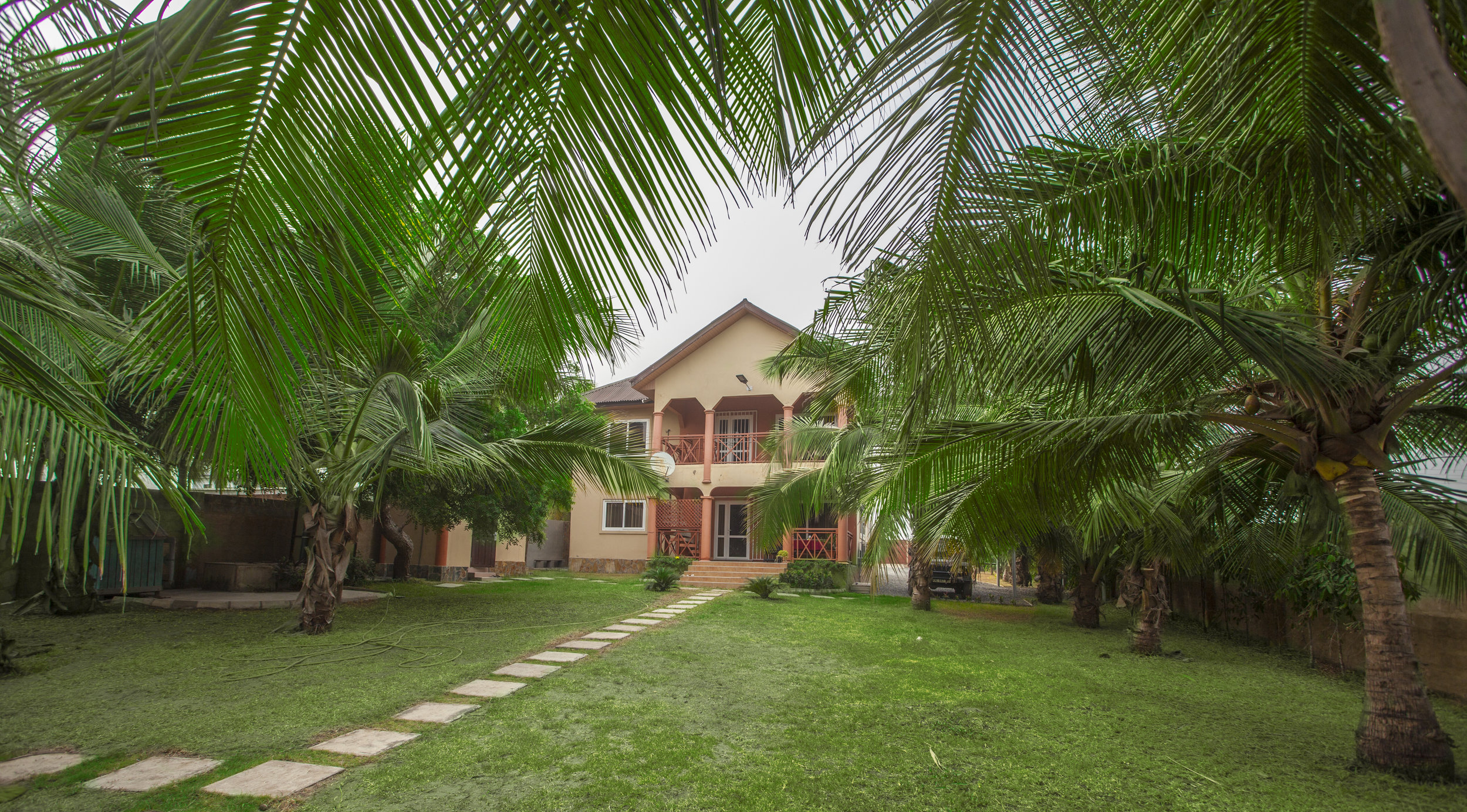 a house with a lawn and palm trees