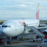 a large white airplane with red and yellow tail