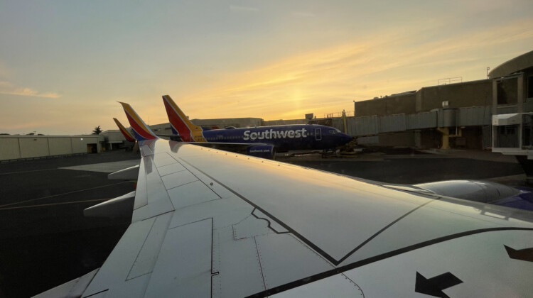 a plane wing with colorful airplanes in the background