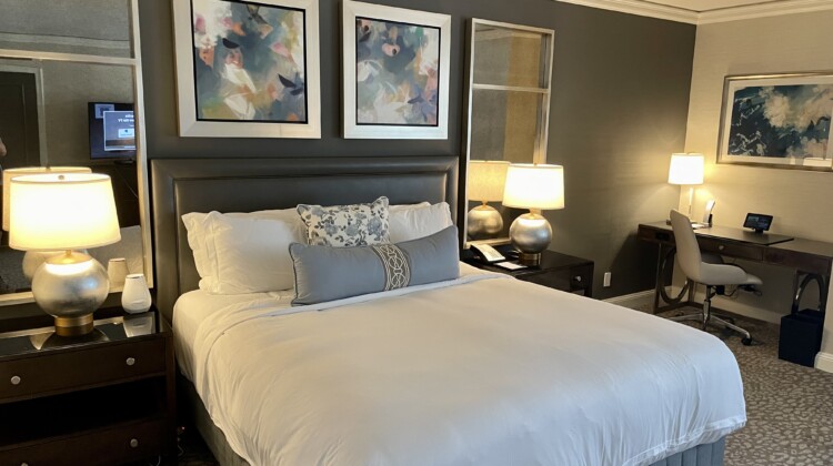 a bed with a white blanket and a lamp on the side