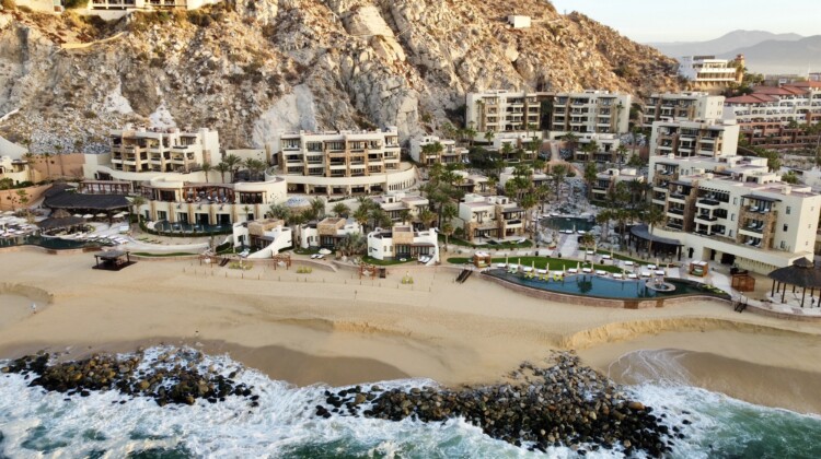 a resort with a beach and a rocky hill
