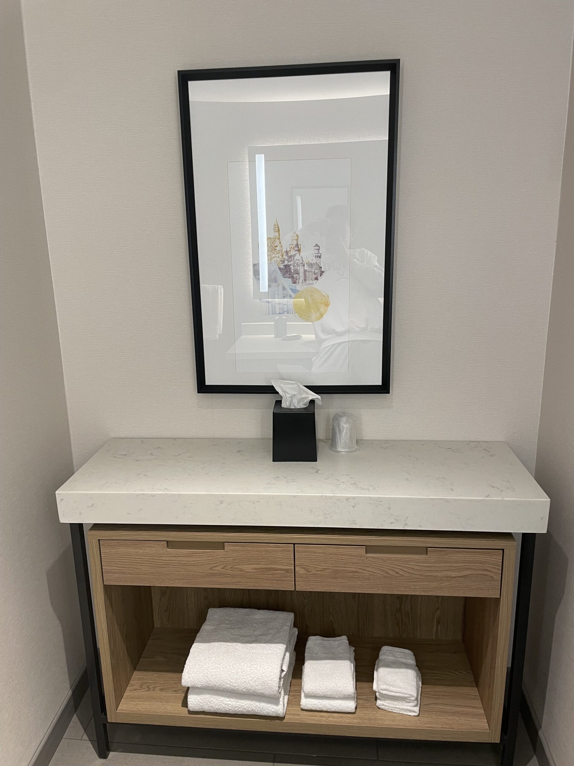 a bathroom vanity with a framed picture on the wall