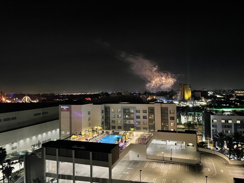 a building with a pool and fireworks in the background