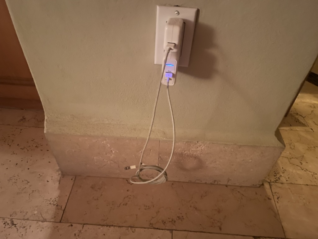 a white electrical outlet with a cord plugged into it