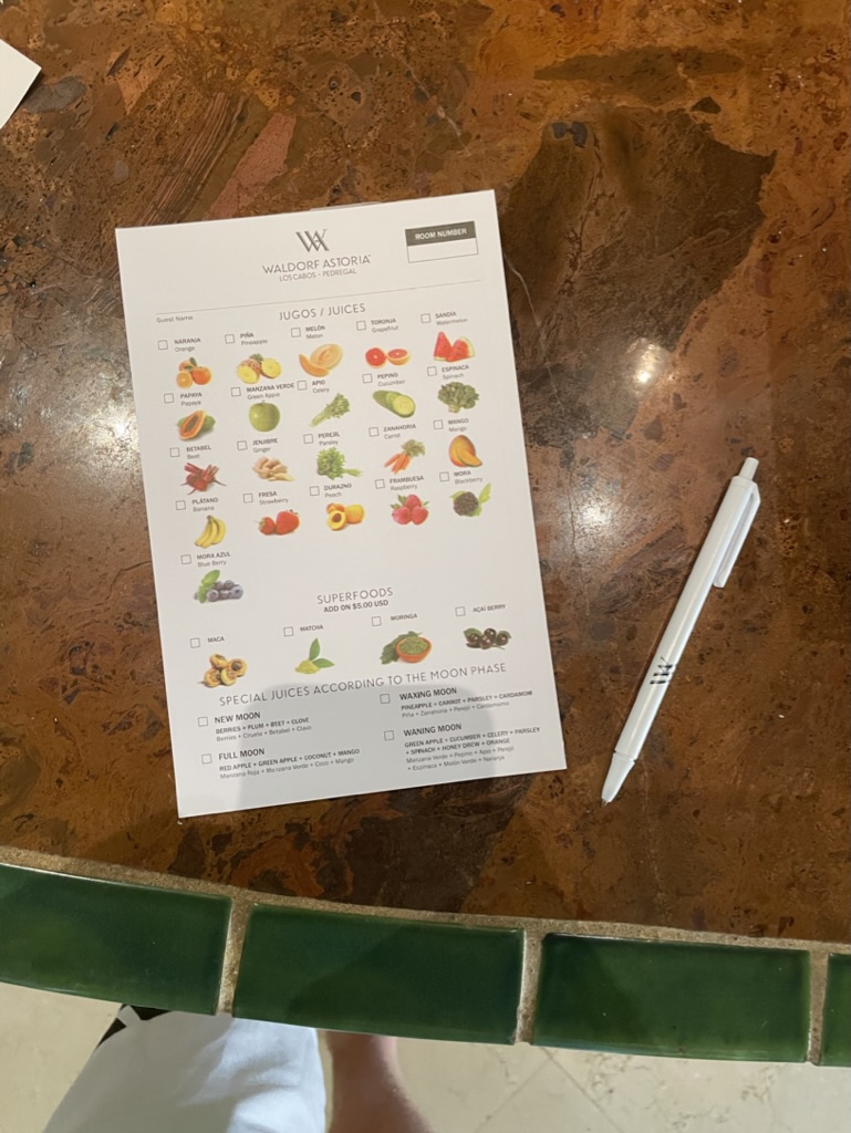 a paper with fruits and a pen on a table