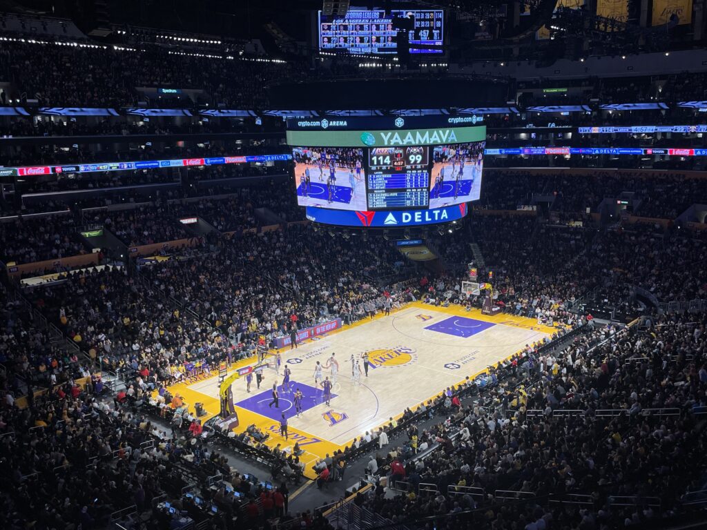 a basketball game in a stadium with Staples Center in the background
