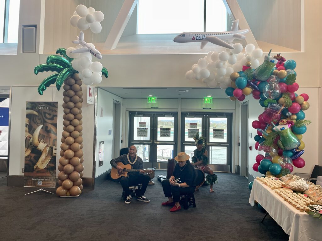 a group of people sitting in a room with balloons and a guitar