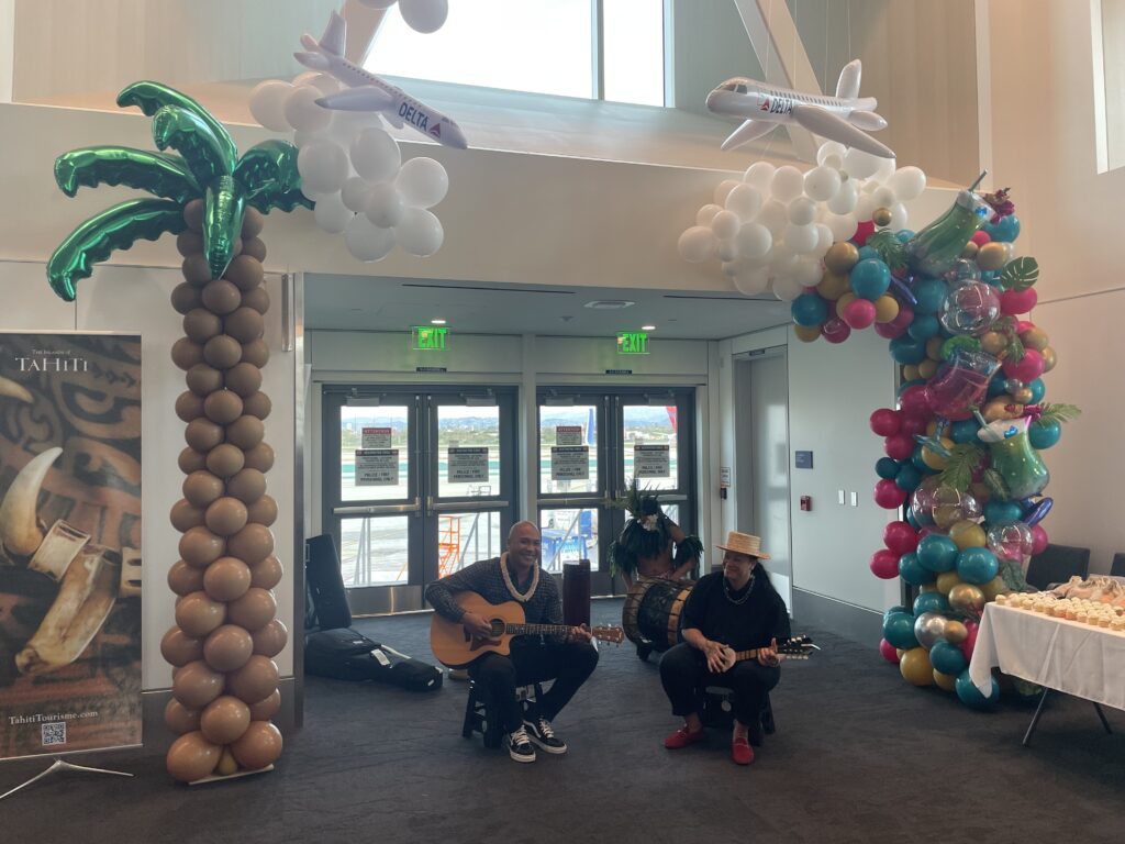 two men playing instruments in a room with balloons
