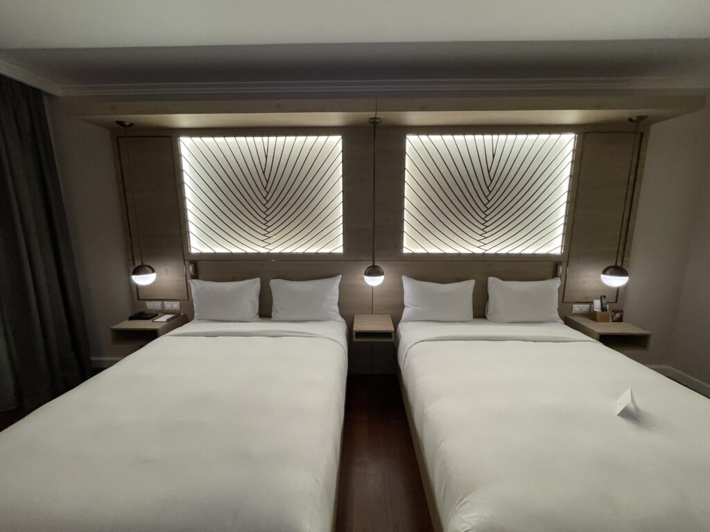 two beds with white sheets and pillows