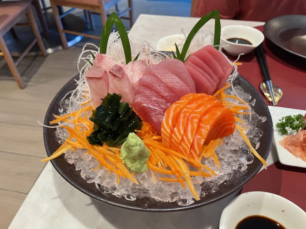 a plate of raw fish and vegetables