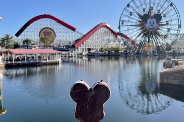a ice cream on a stick in front of a water body with a ferris wheel and a ferris wheel