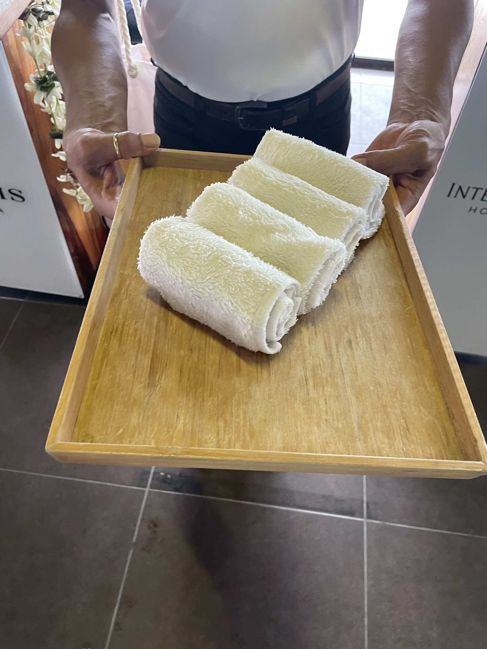 a person holding a tray of towels