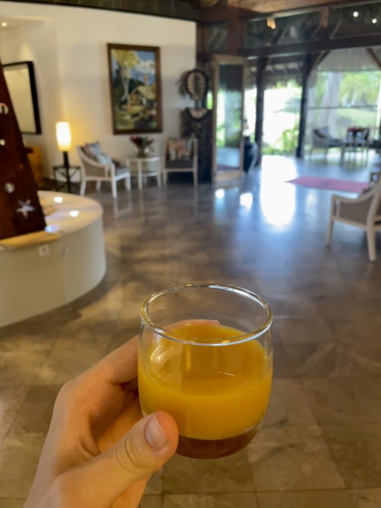 a hand holding a glass of orange juice