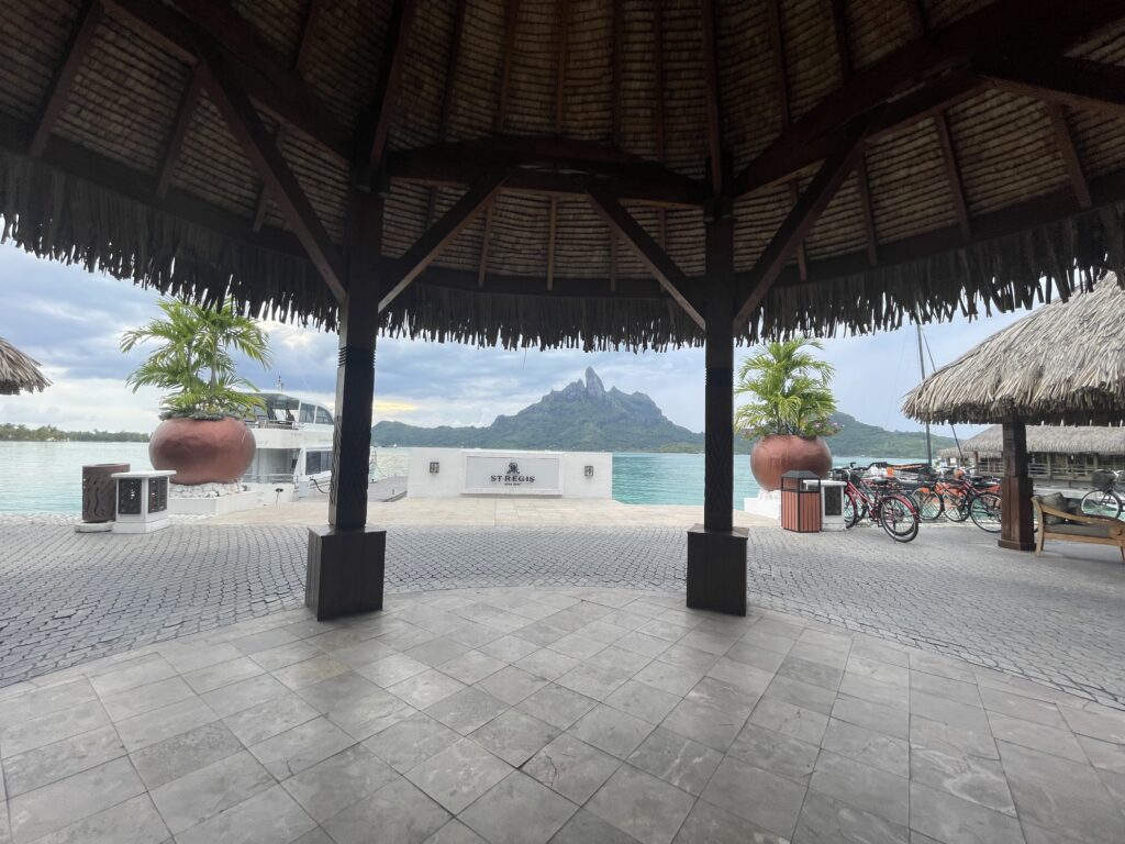 a gazebo with a view of the ocean and a mountain in the background