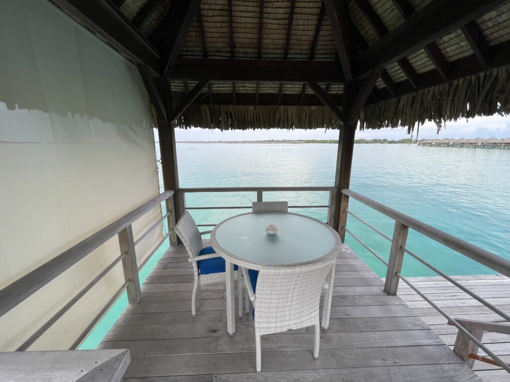 a table and chairs on a deck overlooking water