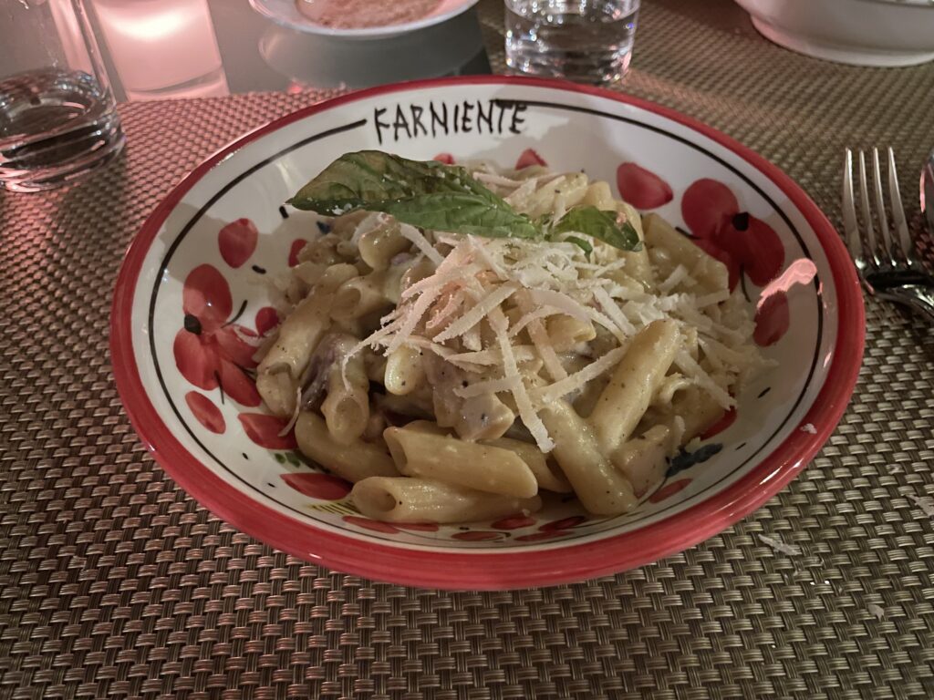 a plate of pasta with cheese and basil