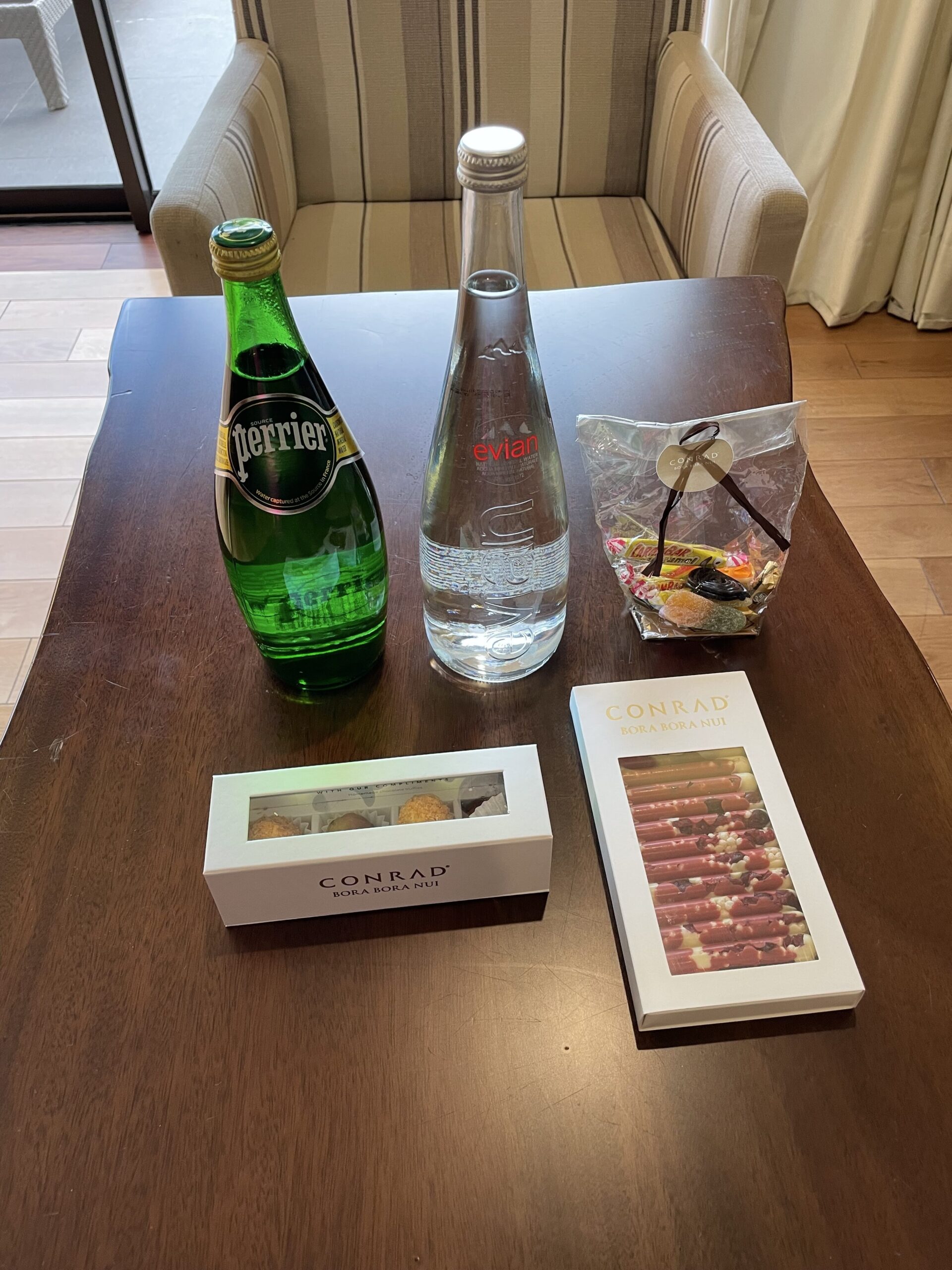 a table with a bottle of water and a box of cigarettes