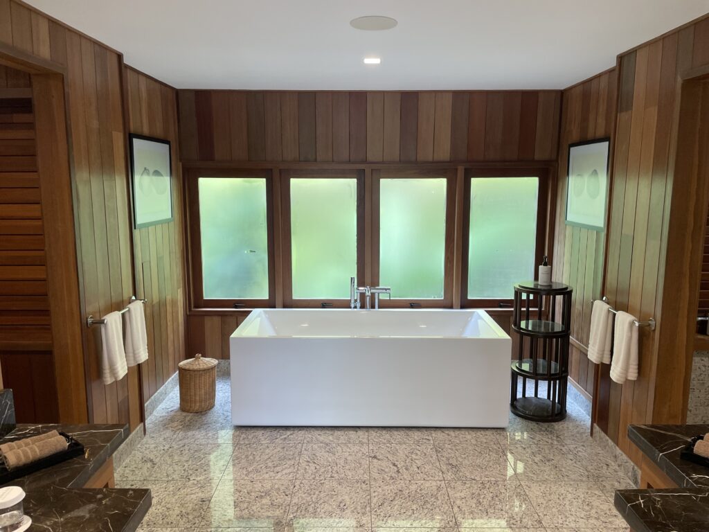 a bathroom with a tub and a wood wall