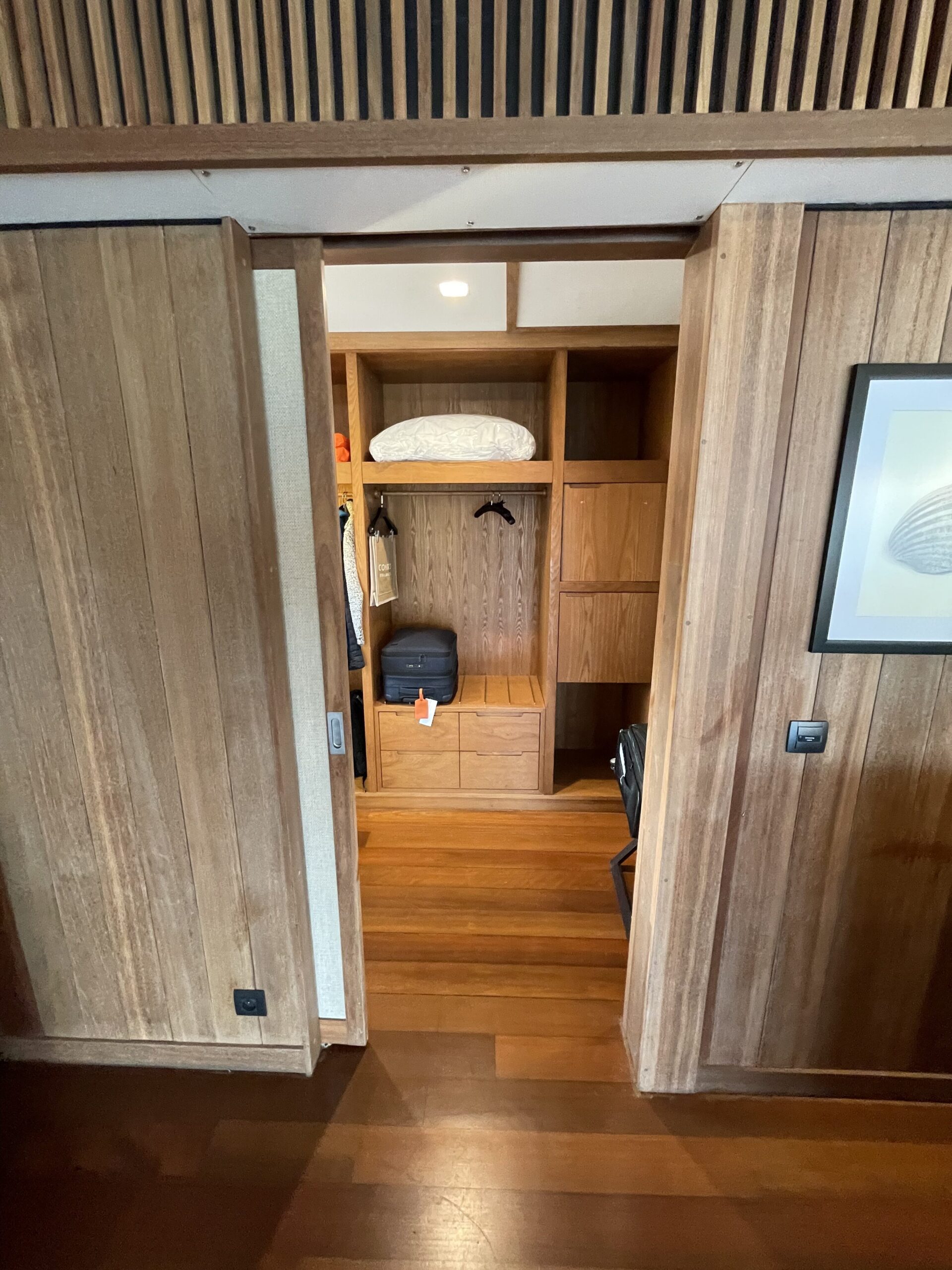 a closet with a bed and luggage