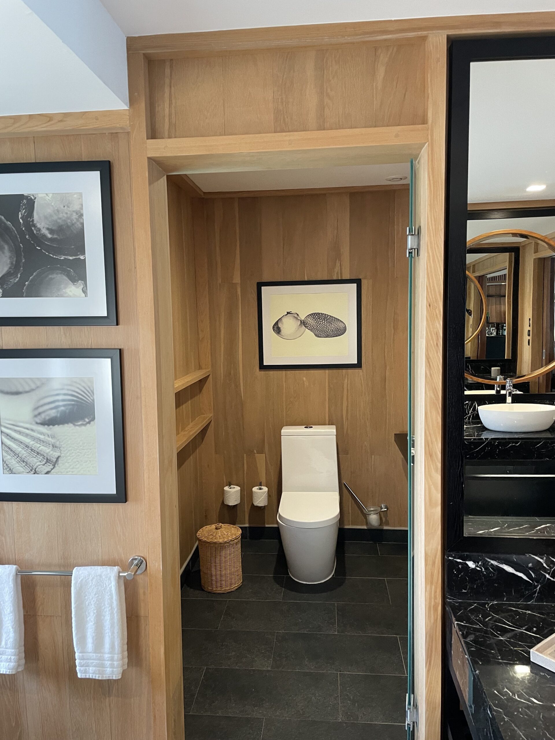 a bathroom with a wood wall and a toilet