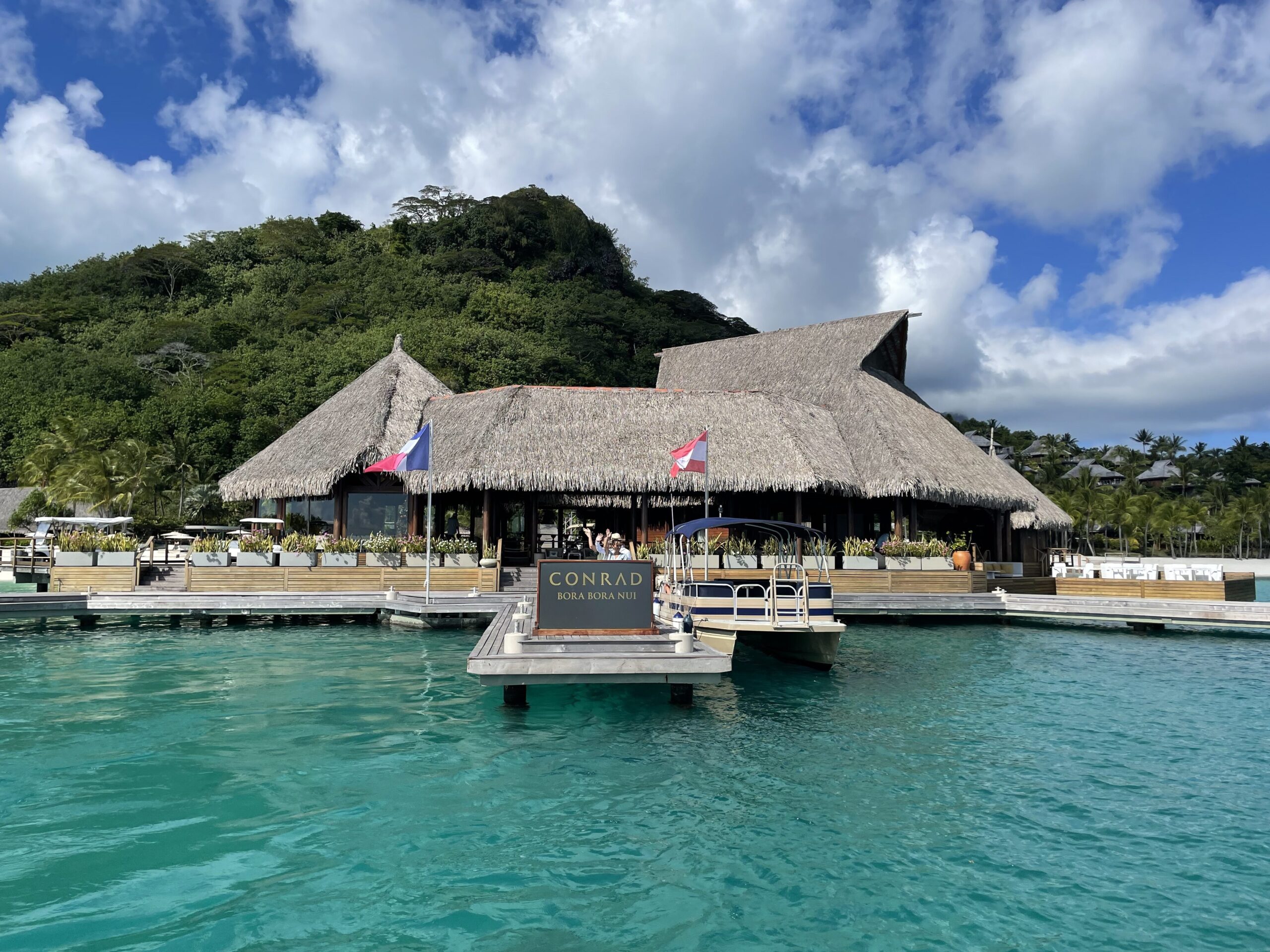 a building with a thatched roof and a dock on the water