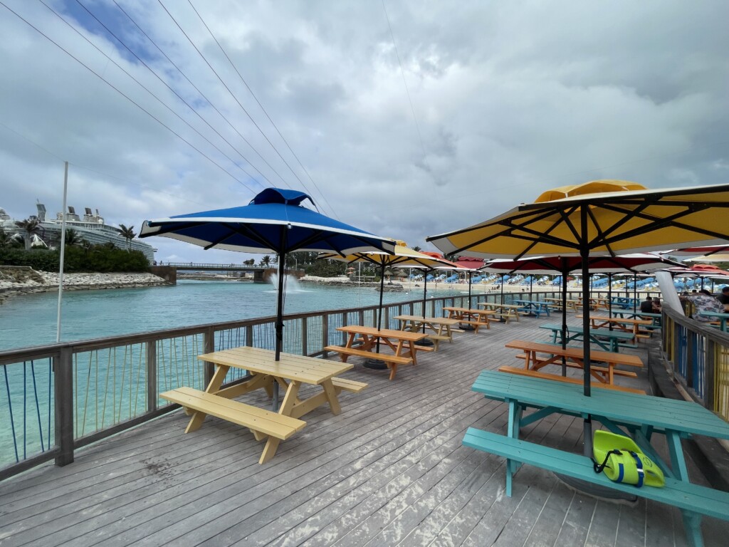 a group of picnic tables and umbrellas on a deck