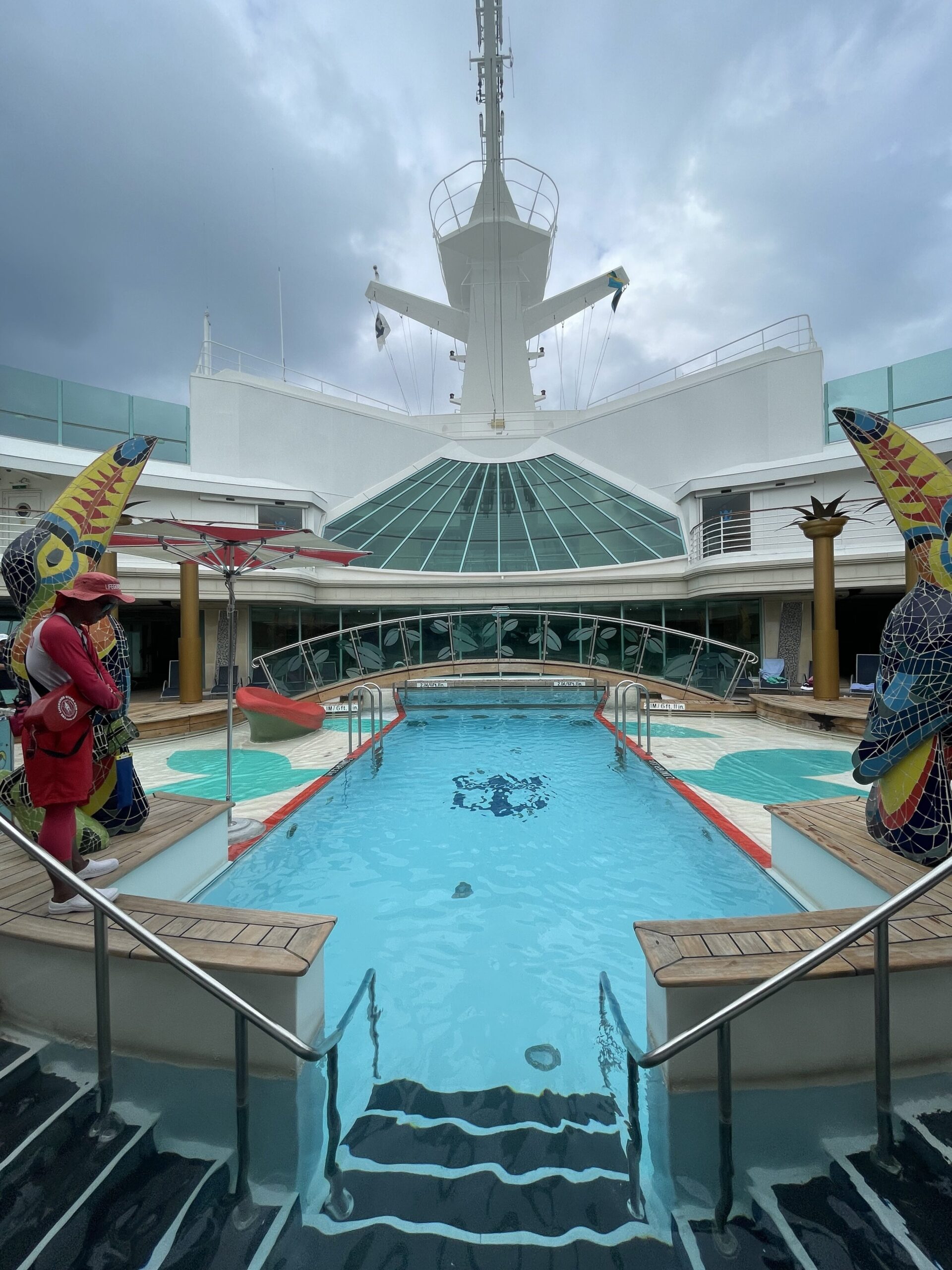 a pool with a couple of people standing in front of a ship