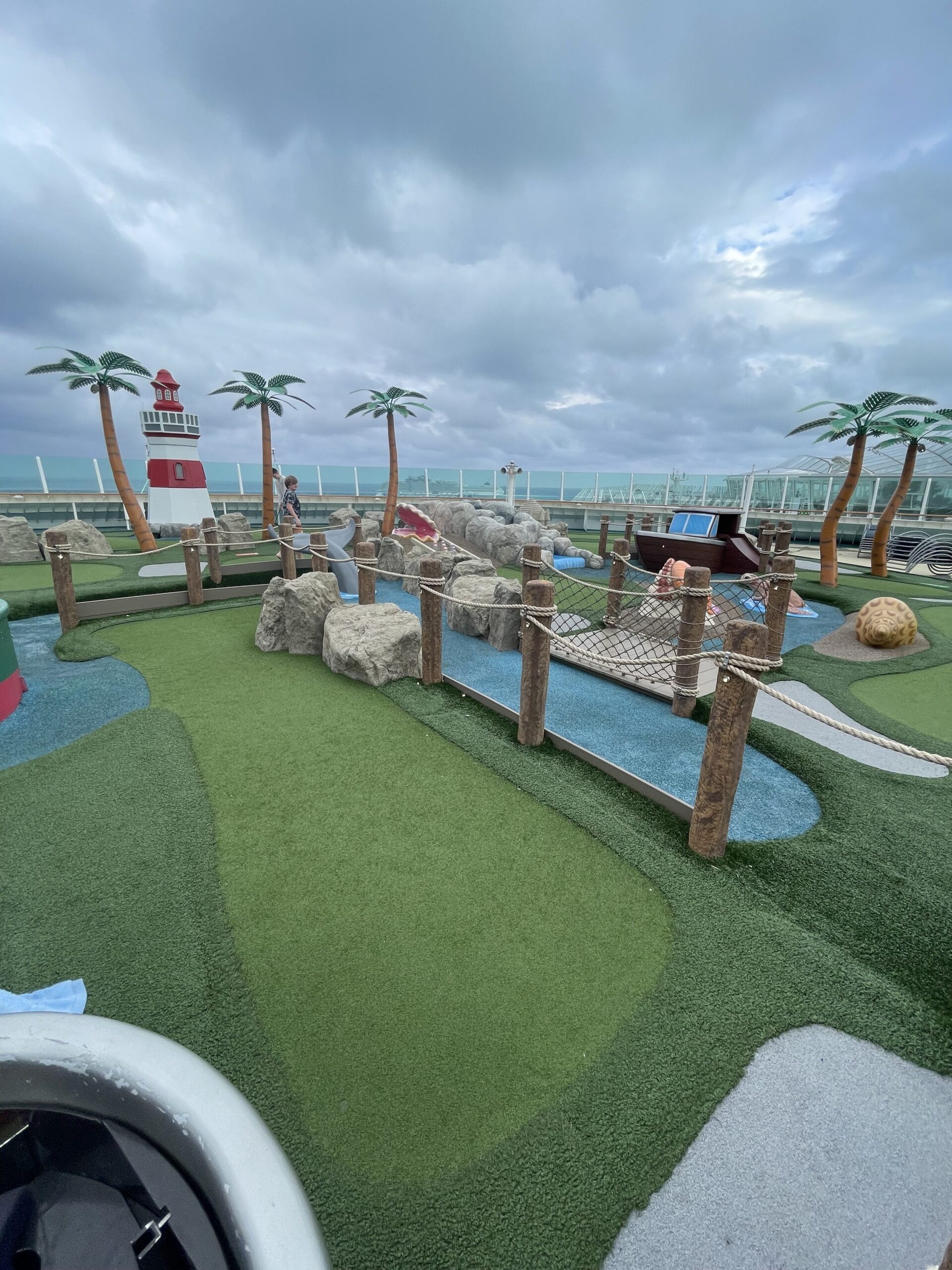 a miniature golf course with a bridge and palm trees