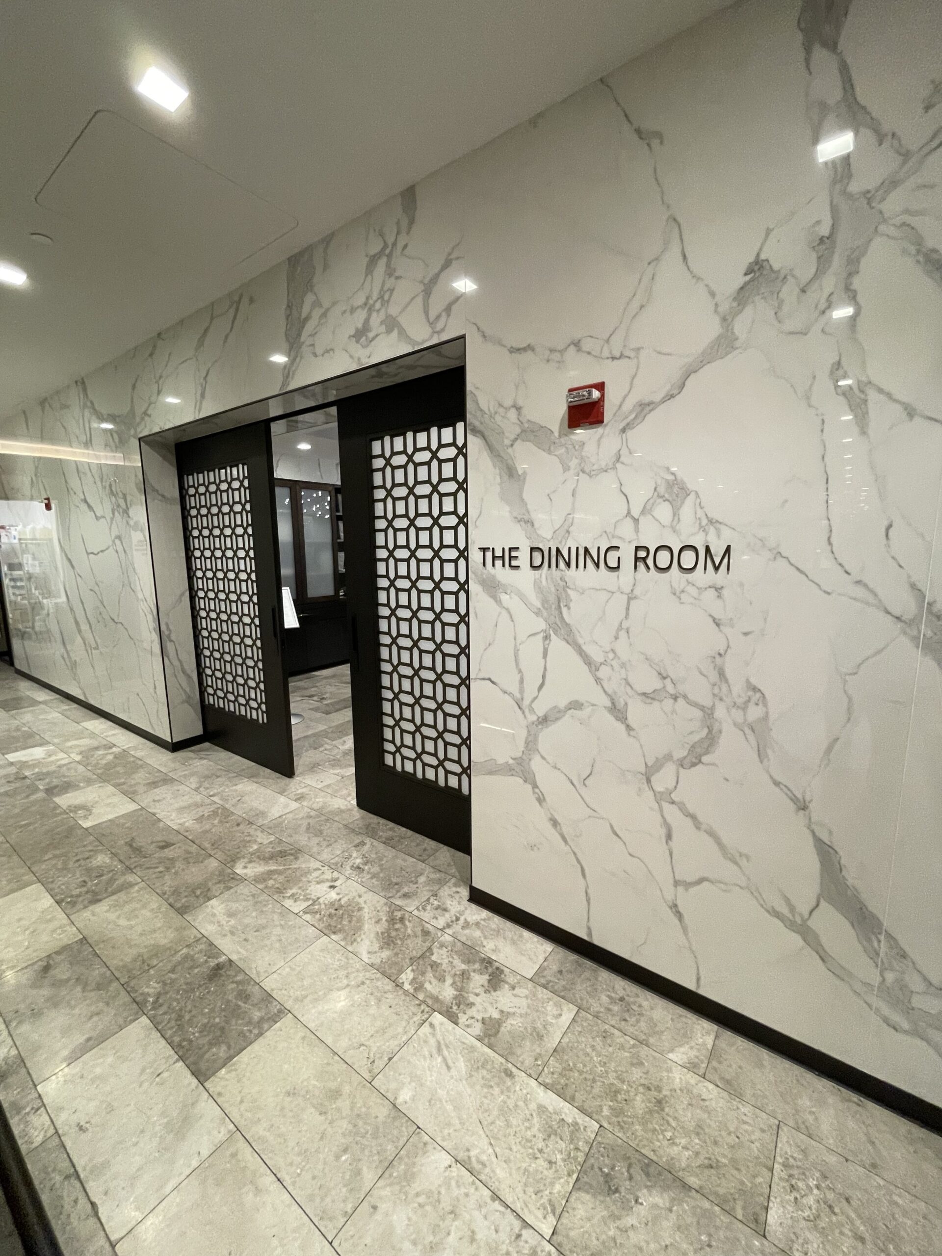 a marble wall with doors and a sign