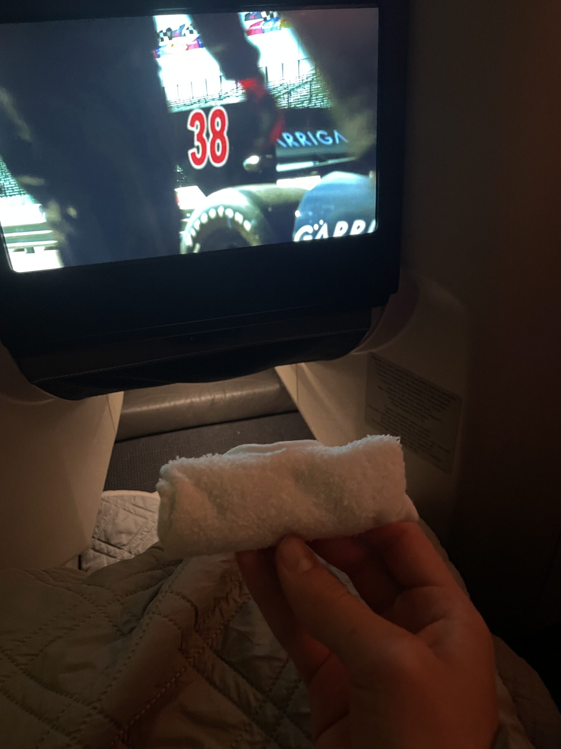 a hand holding a towel in front of a television