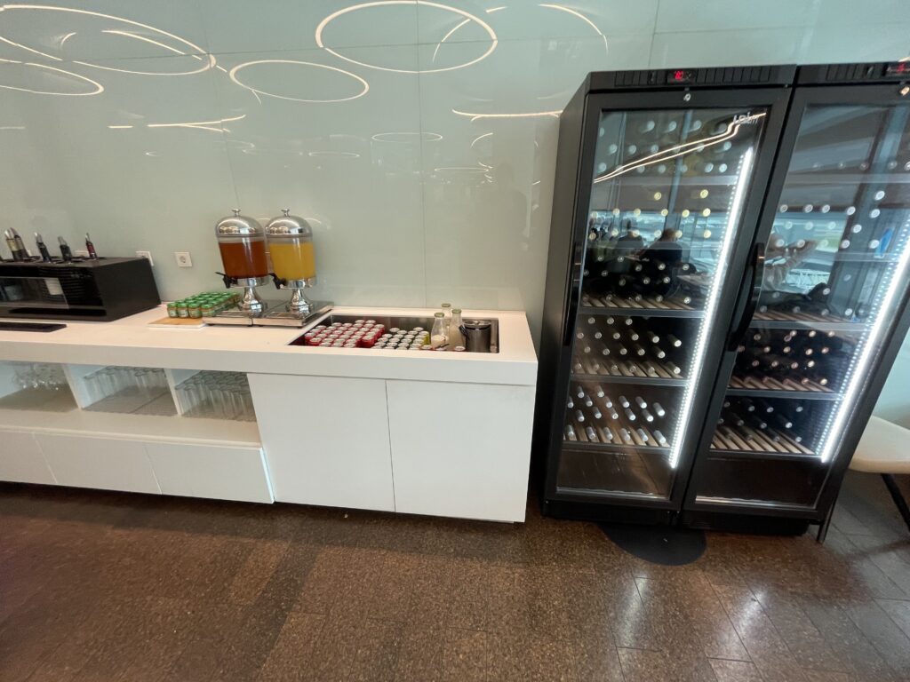 a beverage dispenser next to a refrigerator