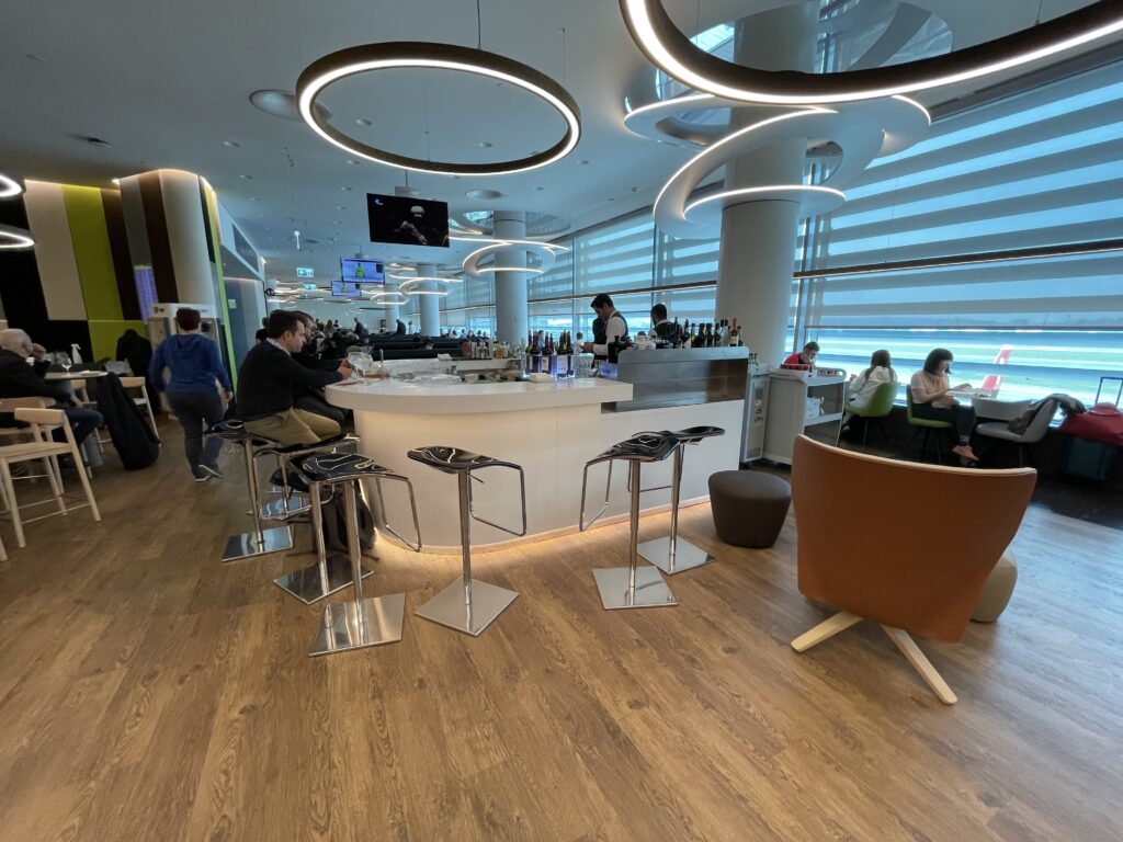 a room with a bar and people sitting around it
