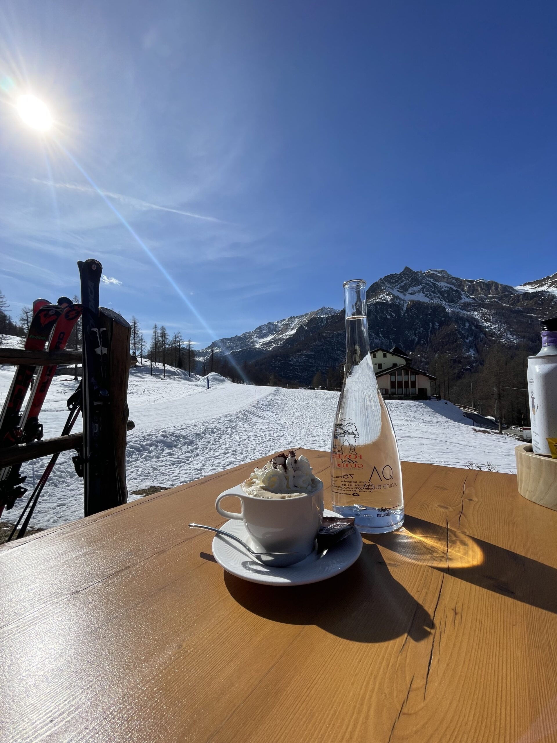 a cup of coffee and a bottle of water on a table with snow