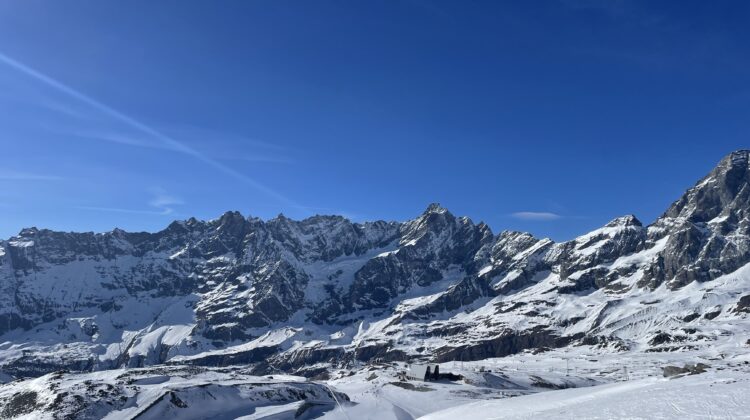 a snowy mountain range with blue sky