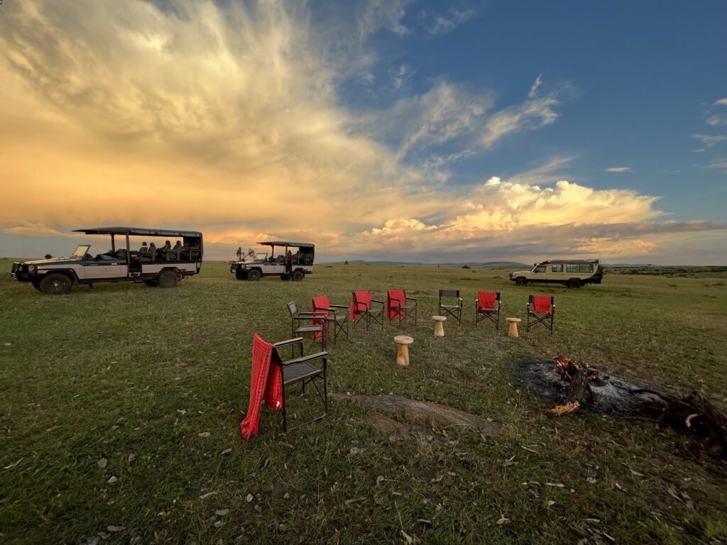 a group of chairs and a campfire in a field