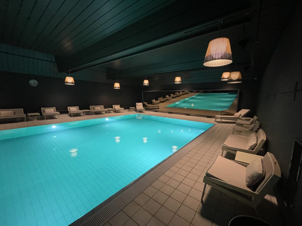 a pool with chairs and a ceiling light