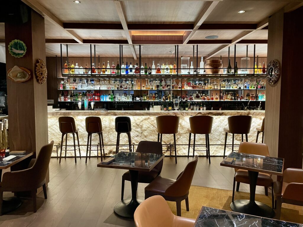 a bar with shelves of liquor and chairs