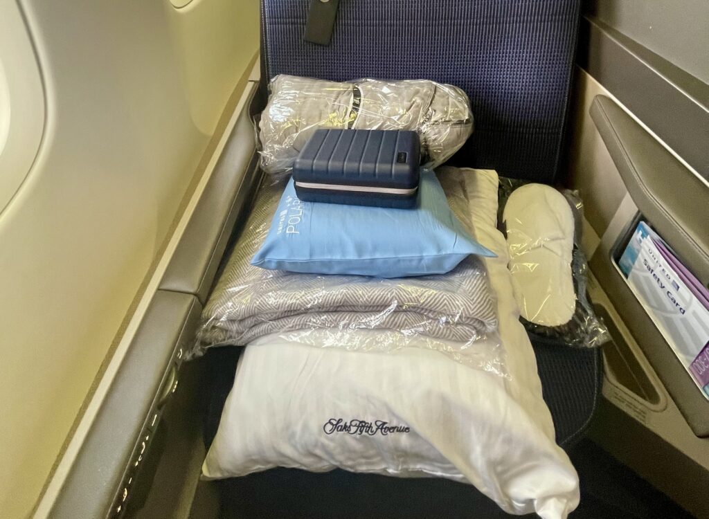 a stack of pillows and blankets on a seat