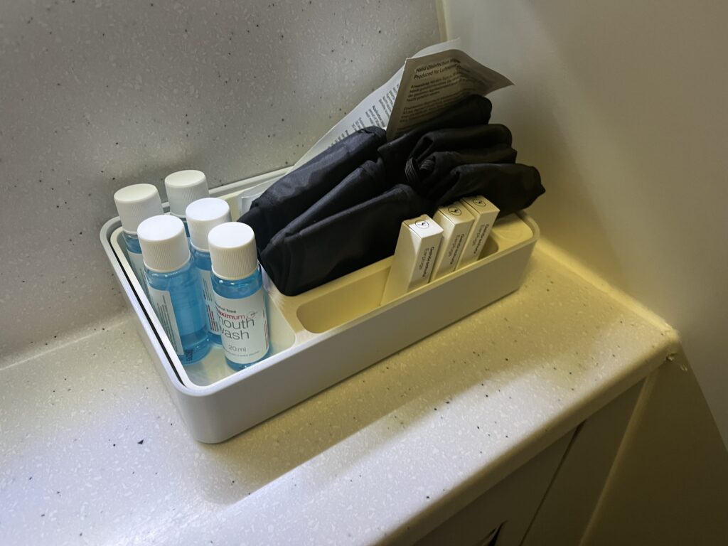 a small white container with small bottles and a black umbrella