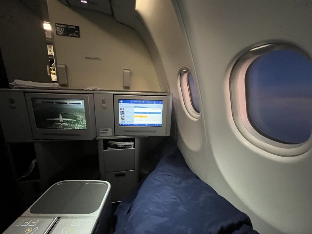 a plane with a bed and two monitors