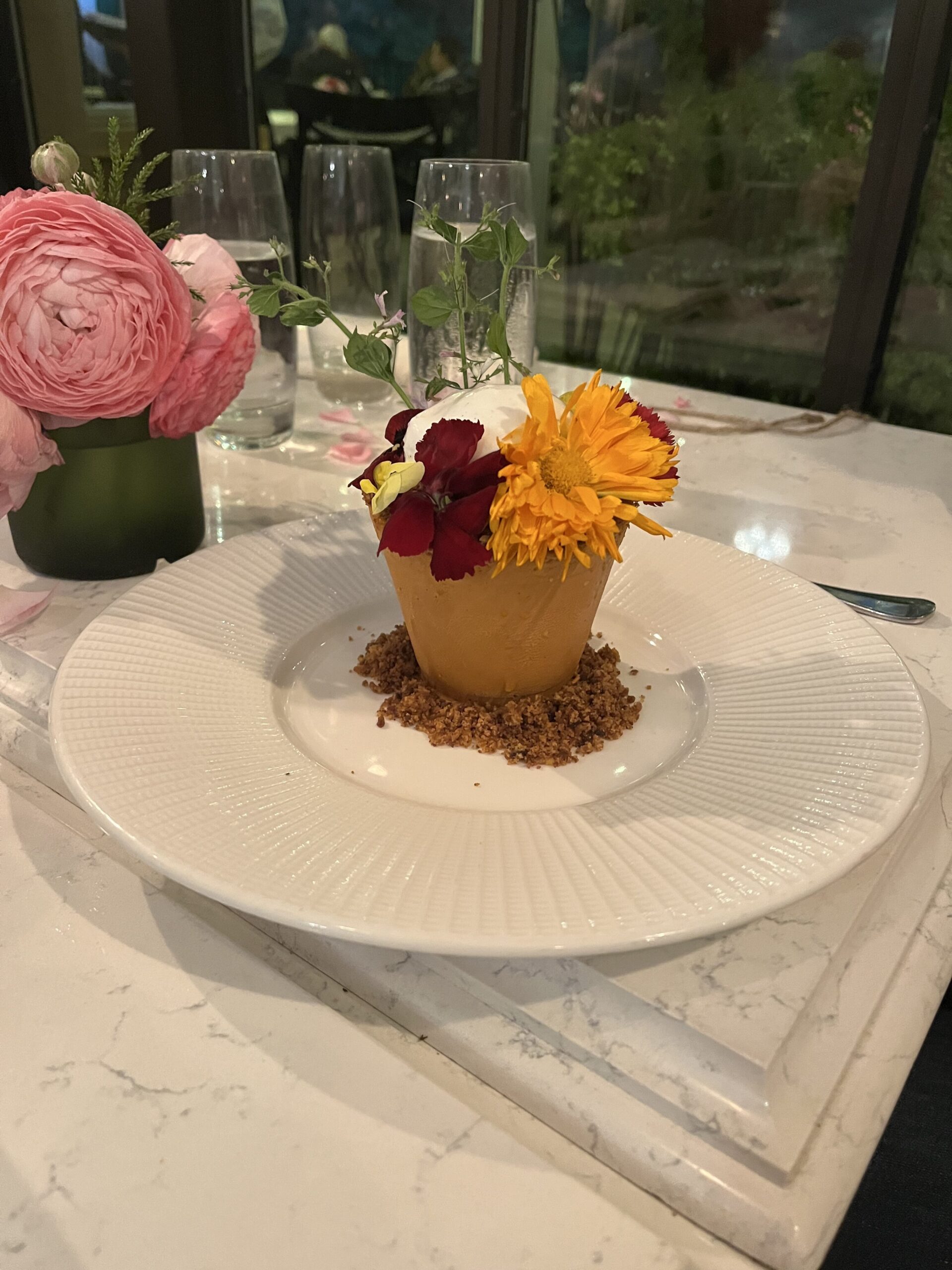 a plate with a cupcake and flowers on it