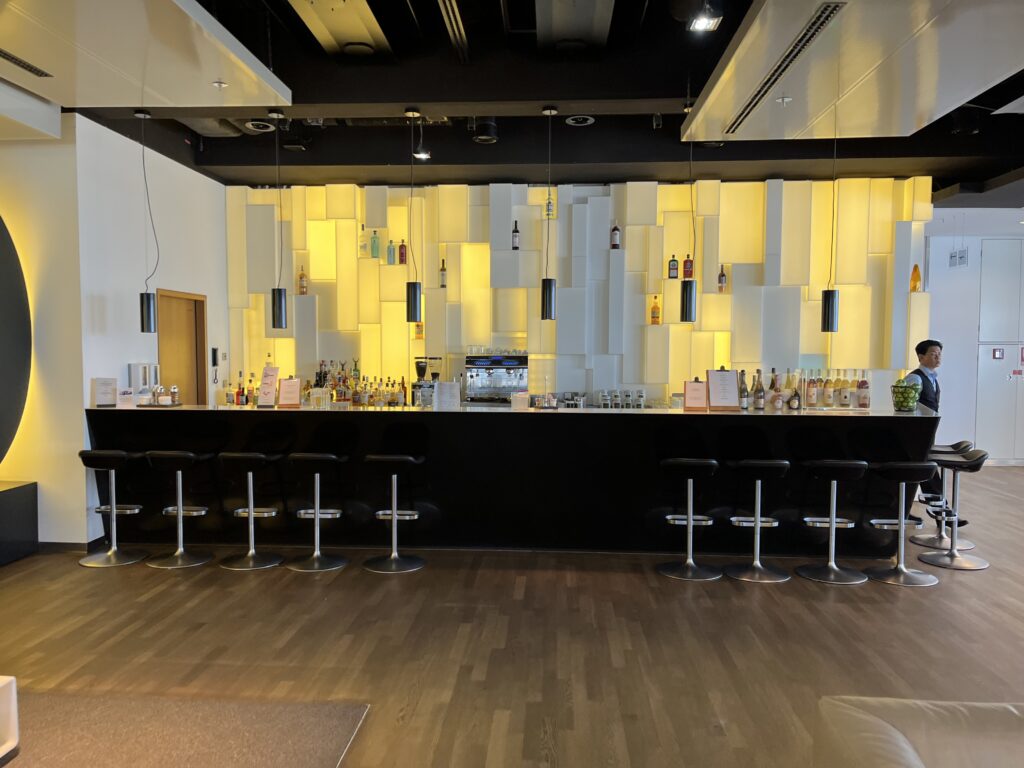 a bar with a row of stools and bottles