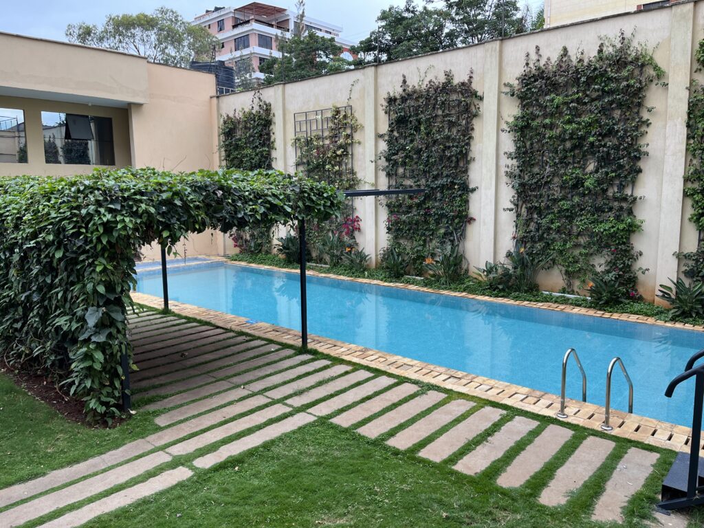 a pool with a fence and plants on the side