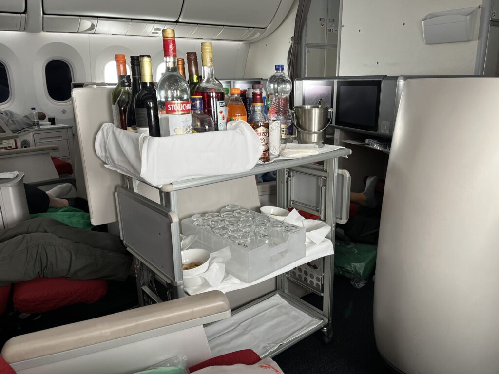 a shelf with bottles and glasses on it in an airplane
