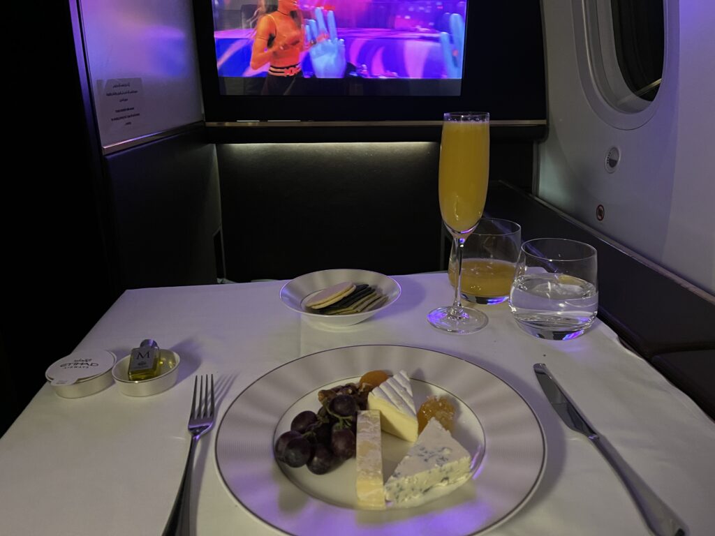 a plate of food and glasses on a table in an airplane