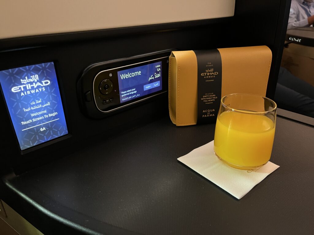 a glass of orange juice and a wallet on a table